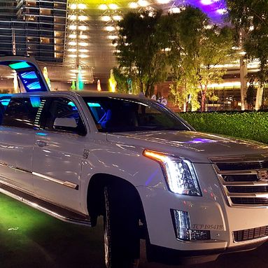 2018 white Escalade limousine with jet doors open at night