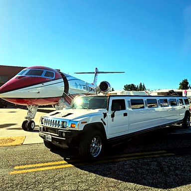 Hummer H2 stretch limousine beside a private jet